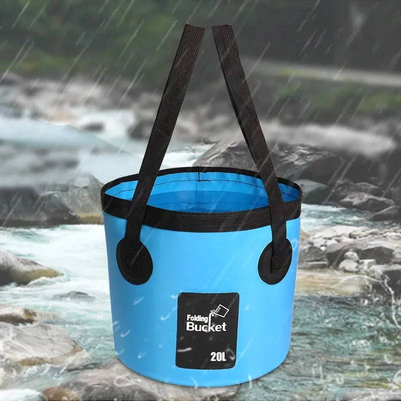 Yellow 20L folding PVC tarpaulin bucket open and standing on grass with water inside