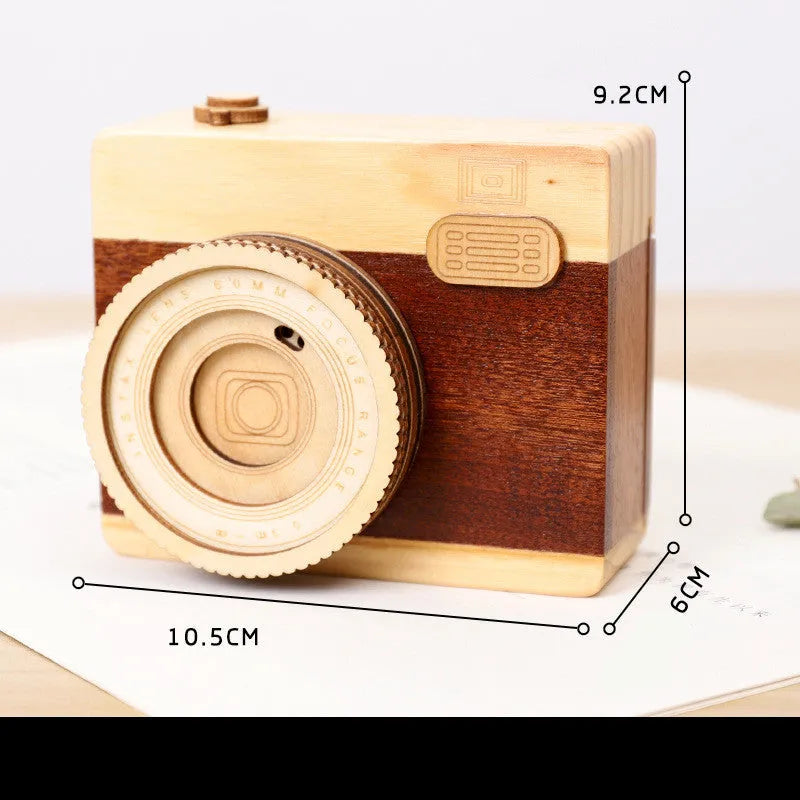 Wooden camera design music box with rotating mechanism on a pine wood base.