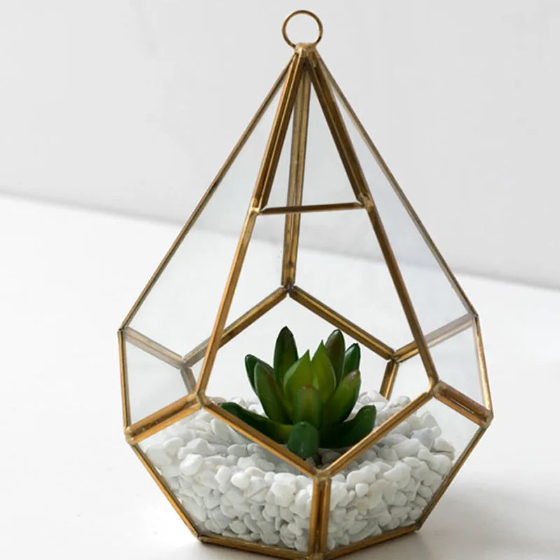 Metal and glass succulent pot decoration in golden love style on a wooden shelf