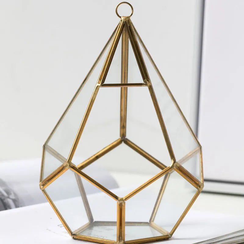Metal and glass succulent pot decoration in golden love style on a wooden shelf