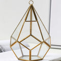 Metal and glass succulent pot decoration in golden love style on a wooden shelf