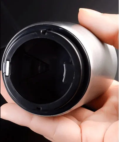 Automatic stainless steel beer bottle opener with magnetic cap catch on a table