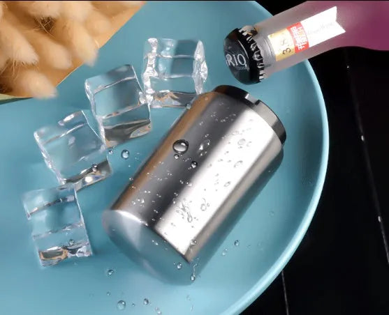 Automatic stainless steel beer bottle opener with magnetic cap catch on a table