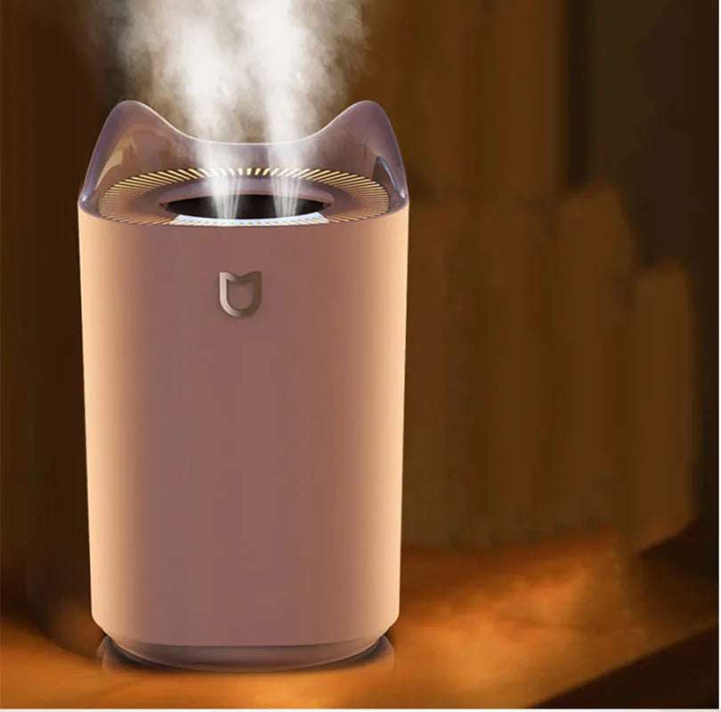 Coral Pink double spray USB humidifier and aroma diffuser with three mist outlets on a wooden table.