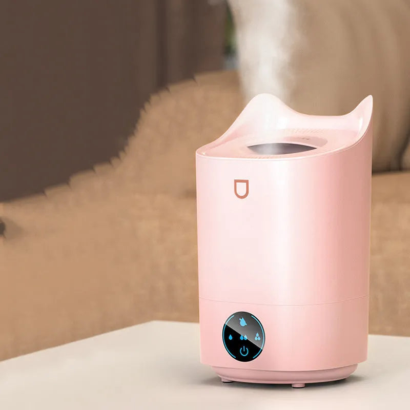 Coral Pink double spray USB humidifier and aroma diffuser with three mist outlets on a wooden table.