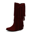 Women's beige suede below-the-knee boots with tassels and a chunky heel on a waterproof platform sole.
