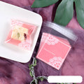 Pink self-adhesive plastic packaging bag with clear window and resealable strip, shown flat and filled.