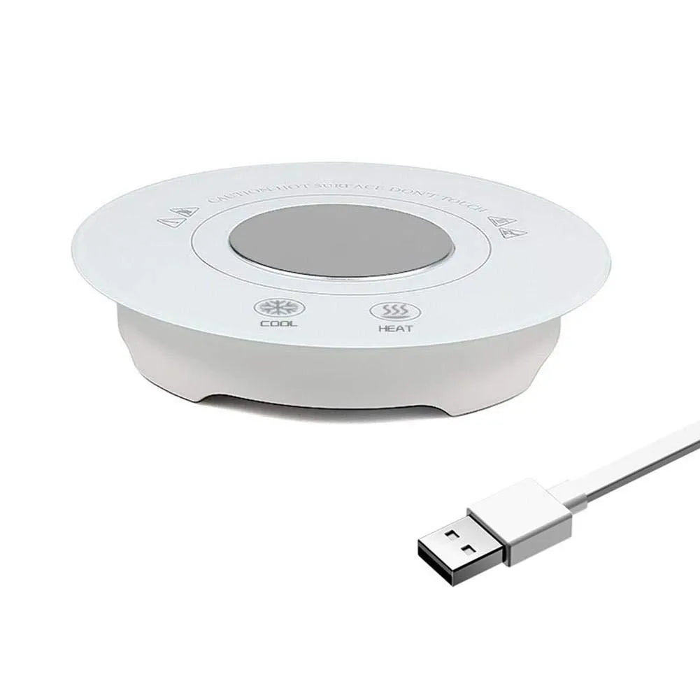 Black USB-powered hot and cold drink coaster with tempered glass top on a wooden desk.