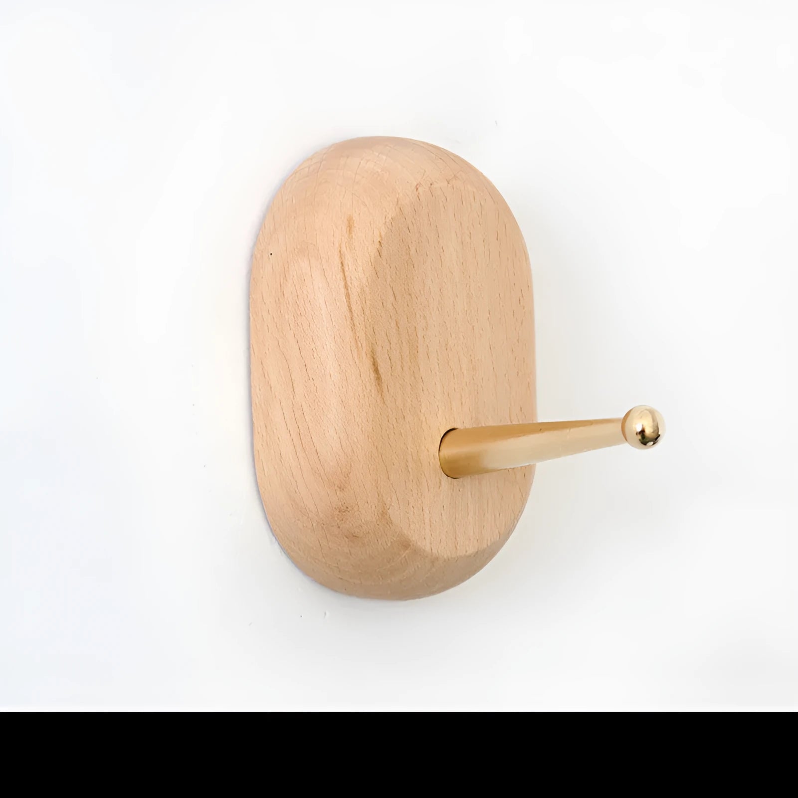 Perforated beech wood wall hook with brass component in modern capsule shape design