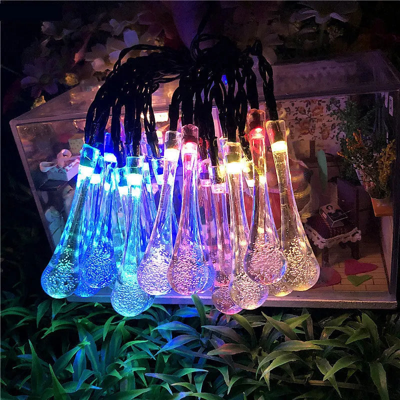 6.5 metre long solar-powered LED garden string lights with white bubble drop shaped lamps on a green lawn