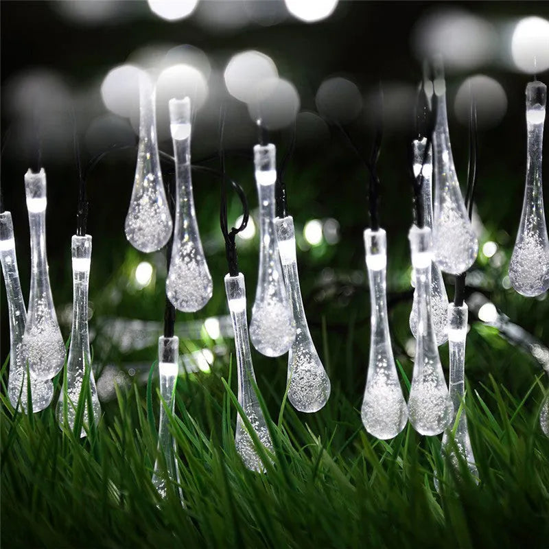 6.5 metre long solar-powered LED garden string lights with white bubble drop shaped lamps on a green lawn