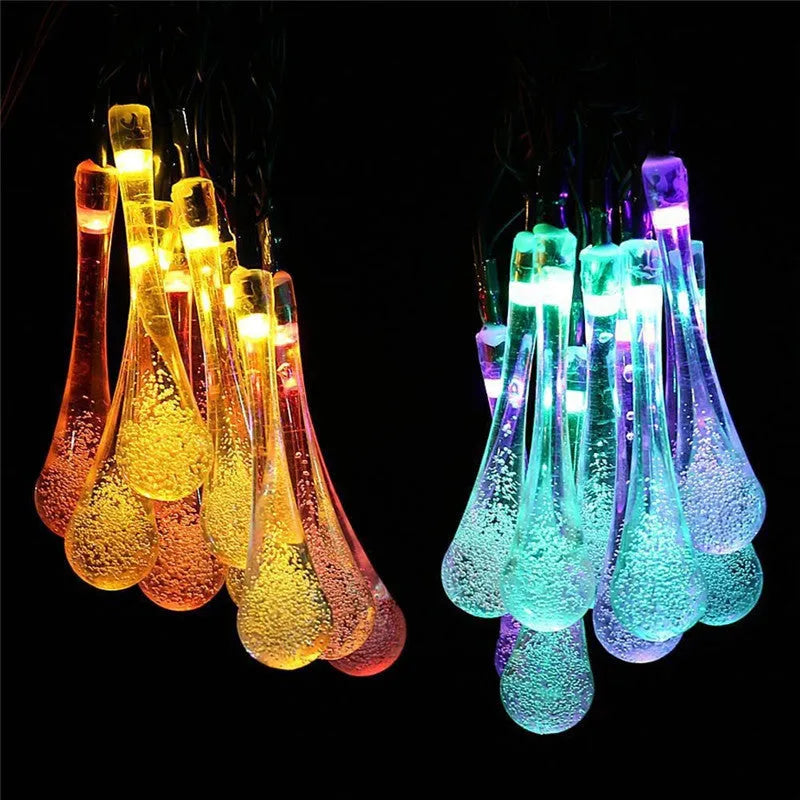 6.5 metre long solar-powered LED garden string lights with white bubble drop shaped lamps on a green lawn