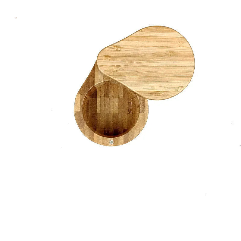 Bamboo seasoning box with a small spoon next to it on a kitchen countertop