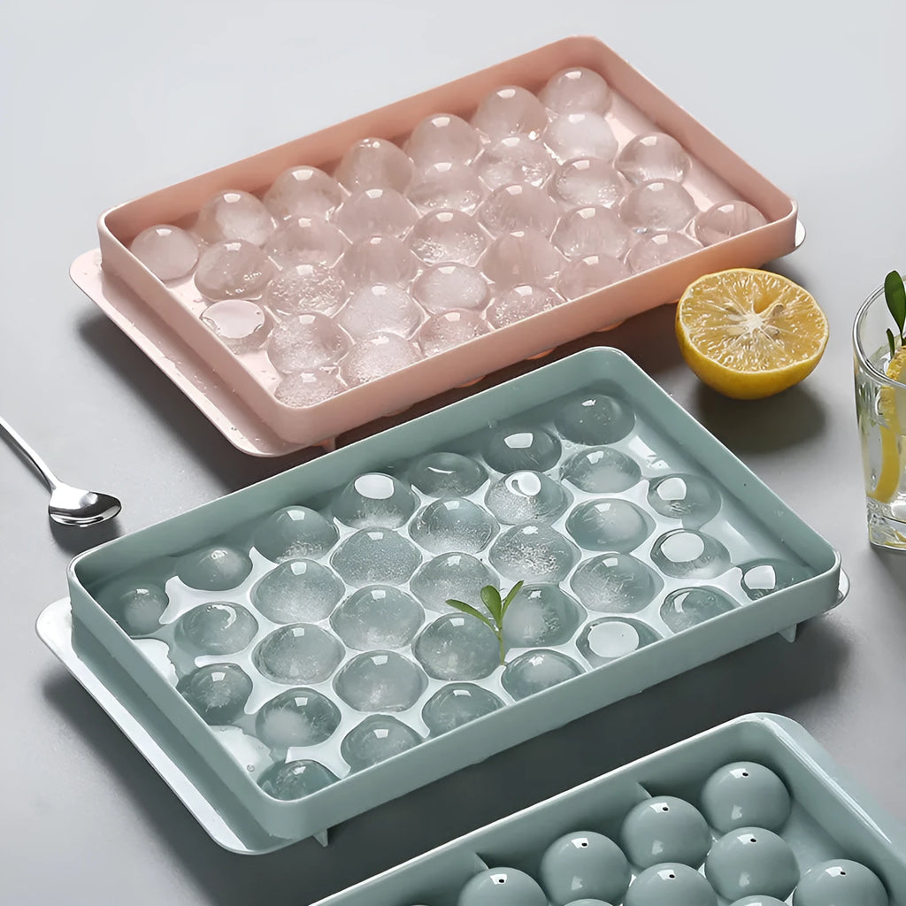 Round ball ice cube tray in sky blue with 33 grids, empty and filled with water, on a kitchen countertop