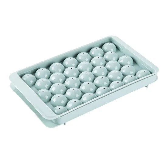 Round ball ice cube tray in sky blue with 33 grids, empty and filled with water, on a kitchen countertop