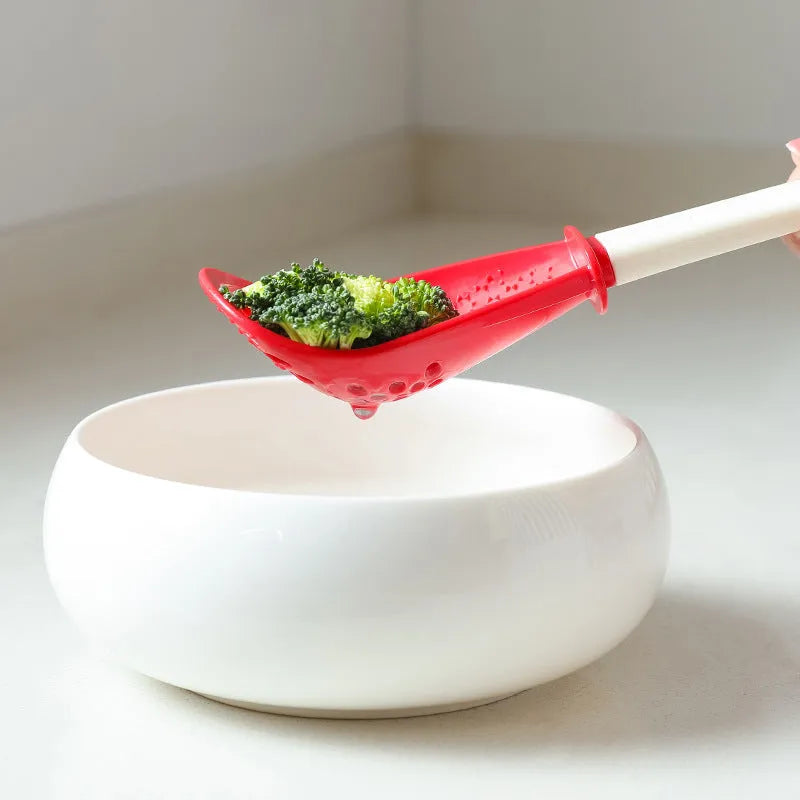Multifunctional slotted cooking spoon in red plastic with serrated edge and half-enclosed head for scooping rice