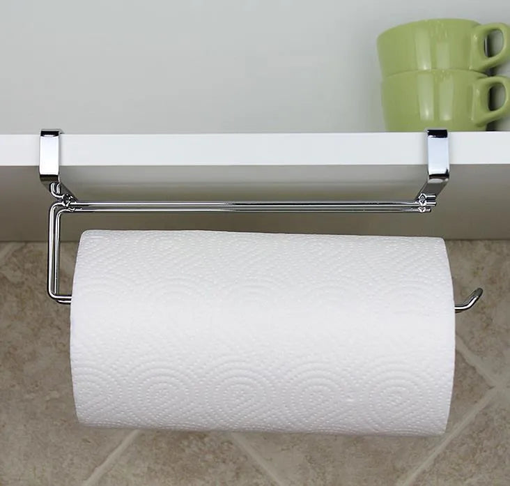 Silver stainless steel paper towel rack hanging on the back of a kitchen cabinet door.