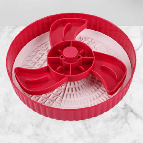 Rotating plastic pet slow feeder bowl with silicone anti-choke mat in windmill pattern.