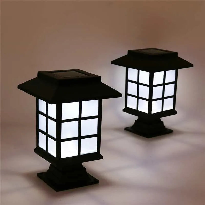 Black solar outdoor LED lawn light with decorative windows, IP65 waterproof, placed in a garden