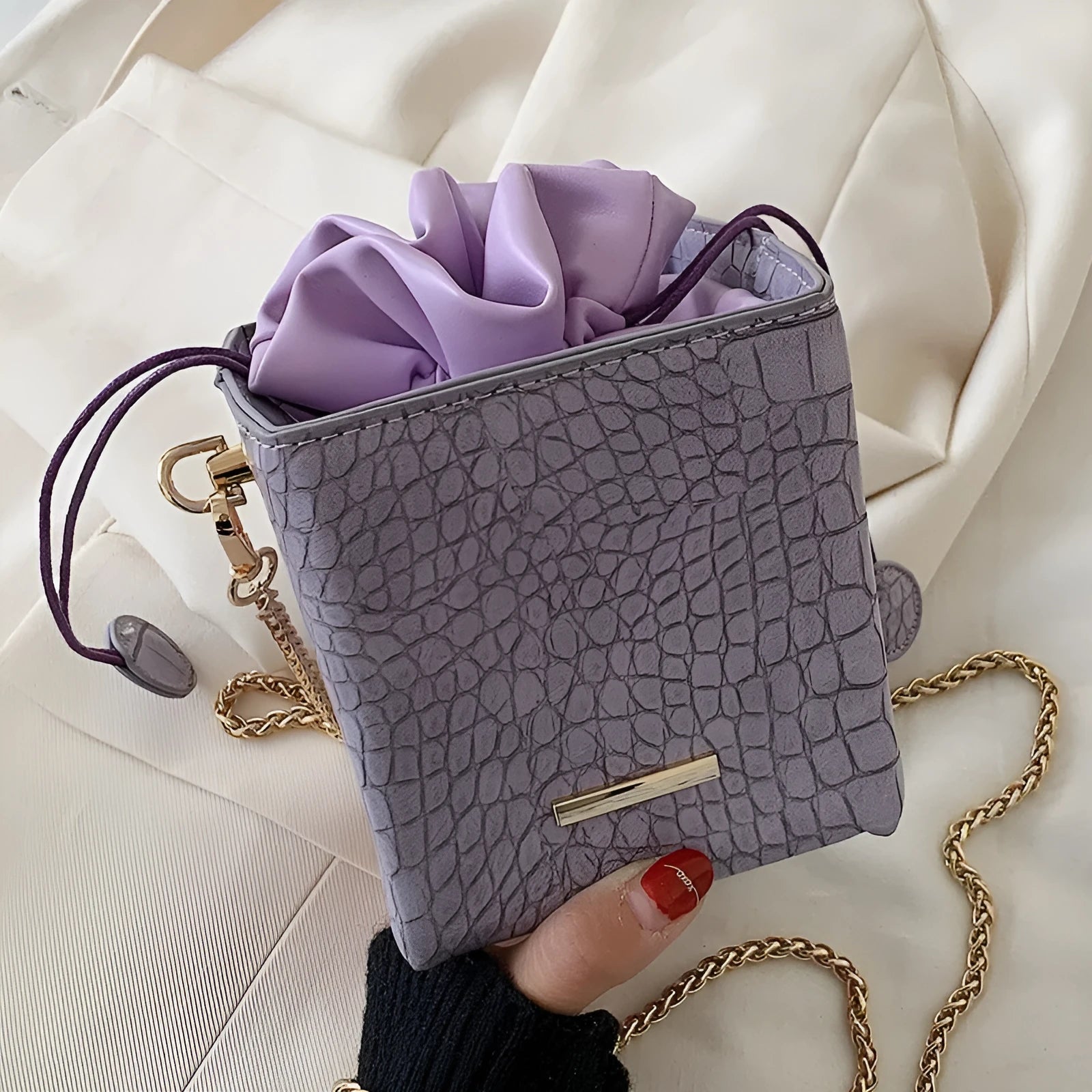Small women's messenger bag with chain strap in six colour options showing bucket shape and zip opening