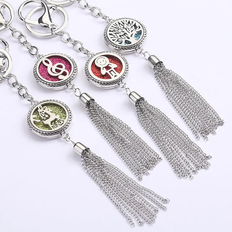 Silver alloy tassel aromatherapy car pendant with long chain on a coloured background.