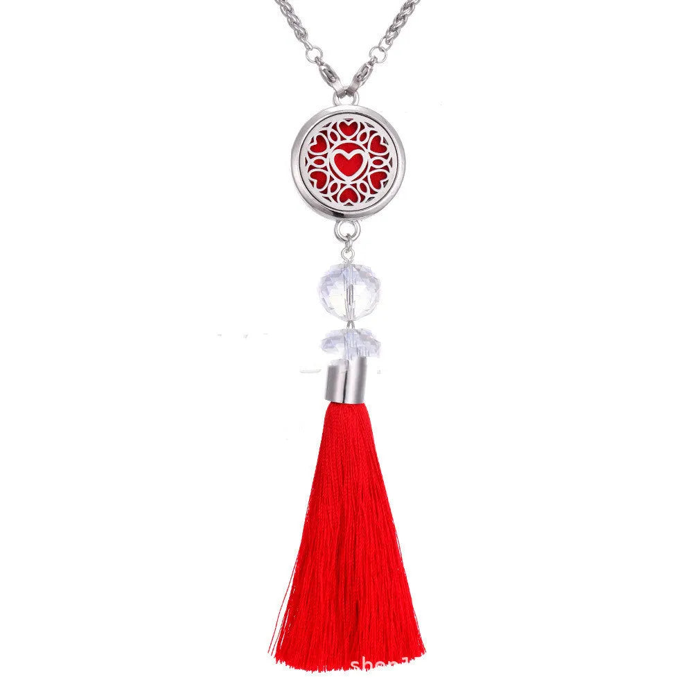 Silver alloy tassel aromatherapy car pendant with long chain on a coloured background.