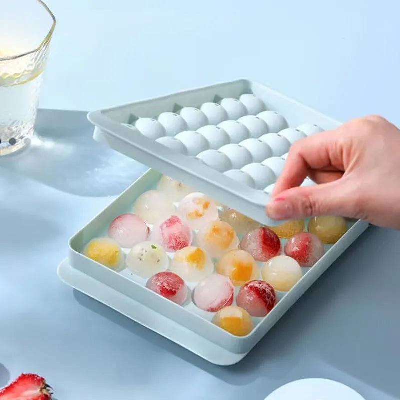 Blue silicone ice cube tray with lid showing 33 round moulds for large ice