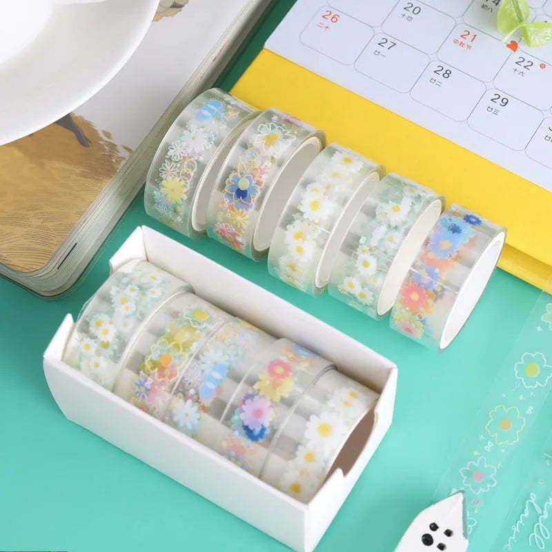 Five rolls of transparent adhesive tape with yellow and white daisy cartoon pattern on a clear background.