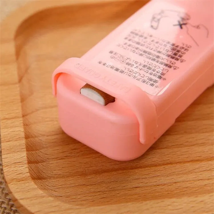 Pink household food clip portable mini plastic bag heat sealer on white background