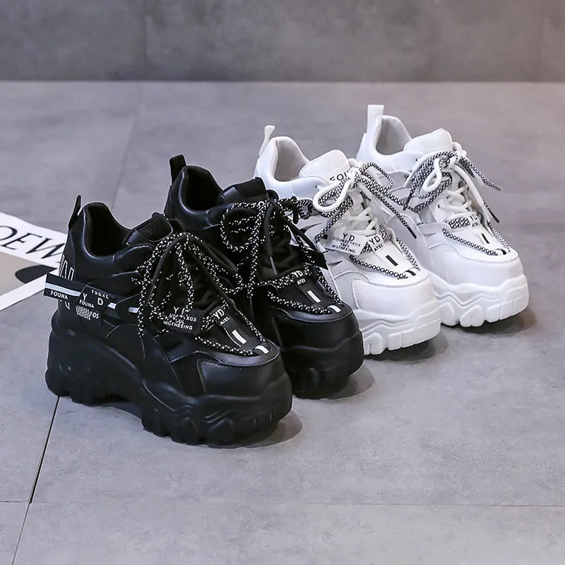White and black women's low-top platform sports shoes with mesh upper and cross strap.