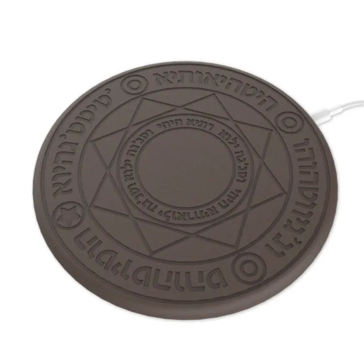 Square black wireless charging pad with illuminated magic array pattern, shown with a smartphone on top.