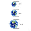 Glow in the dark 3D Earth planet wall sticker in multiple sizes on a wall.