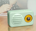 T1 portable Bluetooth speaker in wood grain pink with vintage finish, compact size, and FM radio support