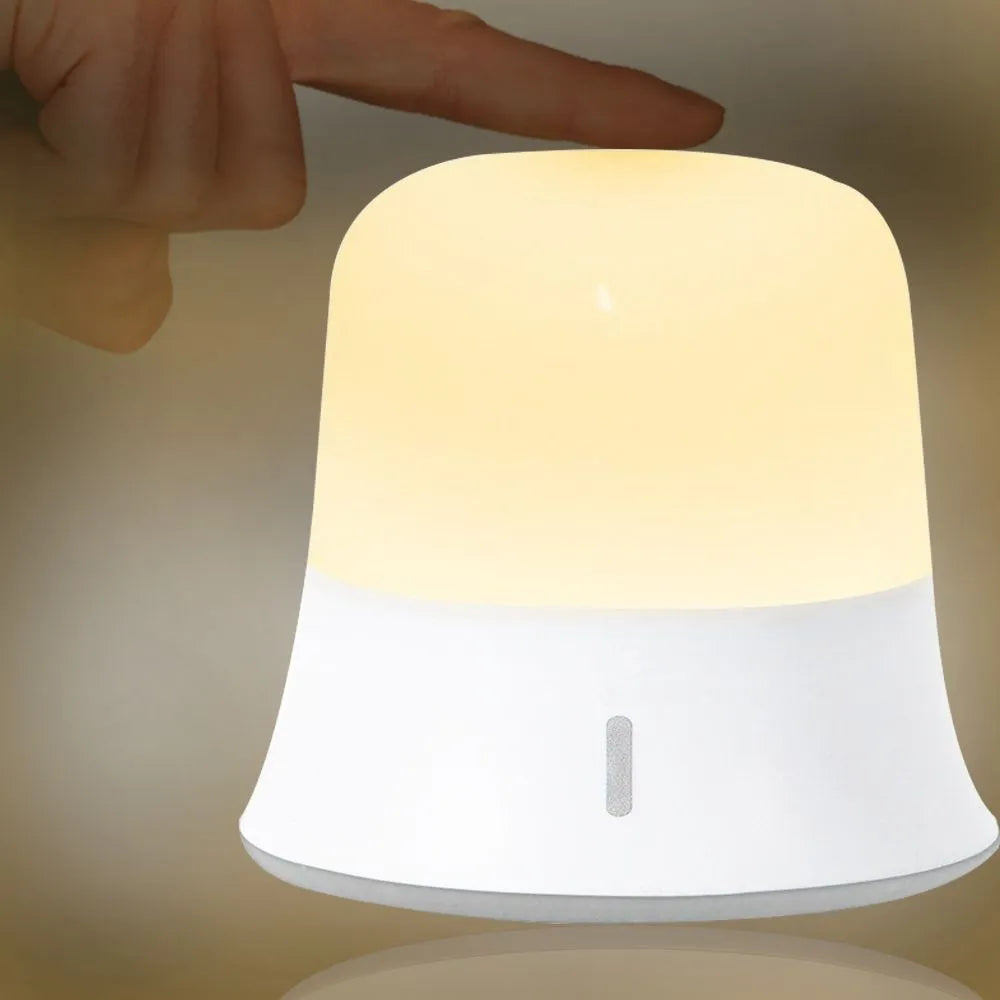 White touch-control bedside night light with RGB colour changing on a wooden table.