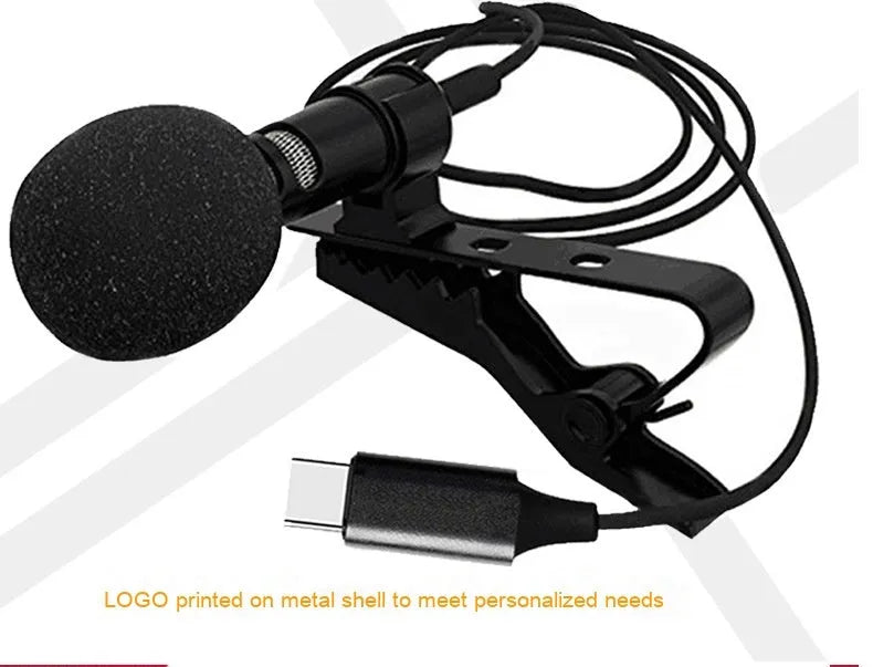 Black USB-C lavalier microphone with metal clip and sponge cover on a table