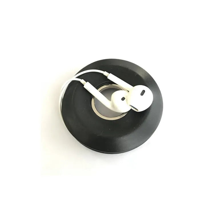 Donut silicone suction cup cord reel in green with earphone cable wound around it and magnet ring closed
