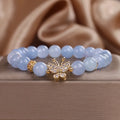 Sky blue crystal butterfly stretch bracelet for women with pearl and rhinestone accents on a plain background