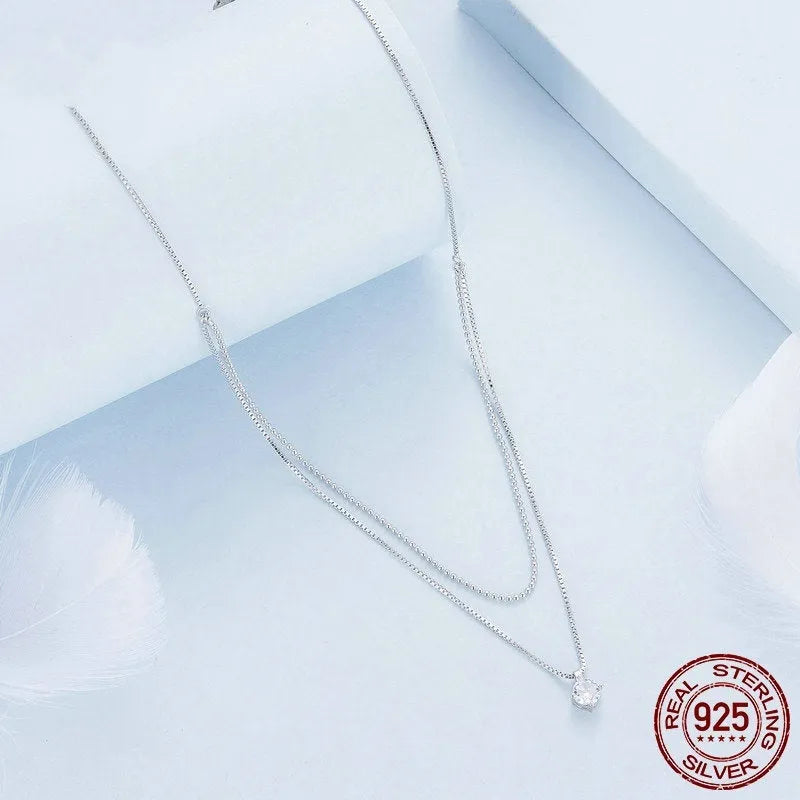 Silver double-layer necklace with pearl chain and sterling silver pendant.