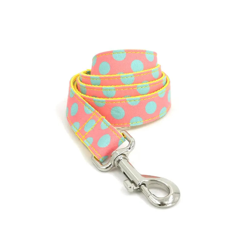 Yellow polka dot dog collar with bow and matching hand-held traction rope on white background