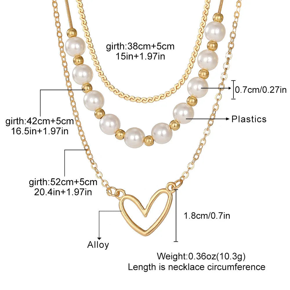 Vintage gold necklace with heart pendant on pearl chain showing adjustable length mechanism