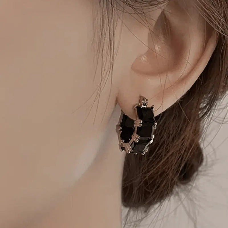 Geometric U-shaped gold earrings with round black zircon crystals