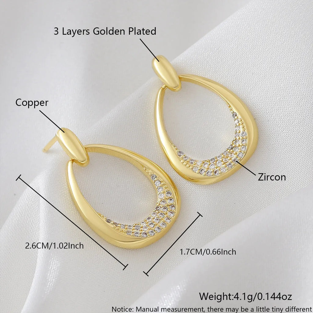 Women's yellow gold geometric drop earrings with simple zircon detail showing oval and round design elements