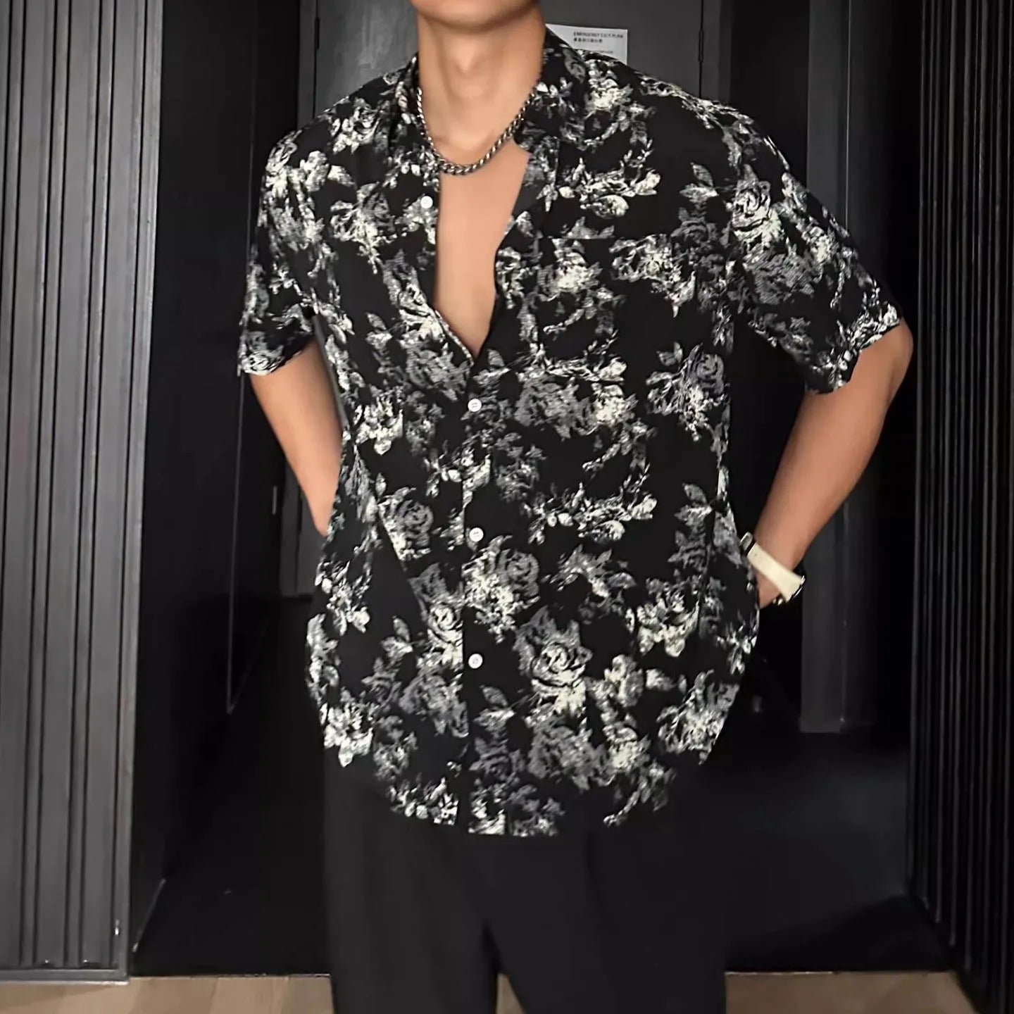 Loose fit black floral print short sleeve casual shirt on a hanger