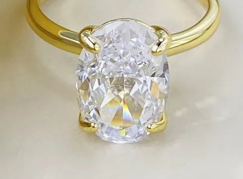 Oval solitaire ring in sterling silver with a four-prong setting and a central gemstone.