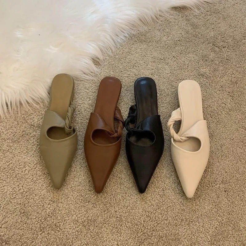 Women's soft leather semi-toe box slippers in black with rubber sole, side view.
