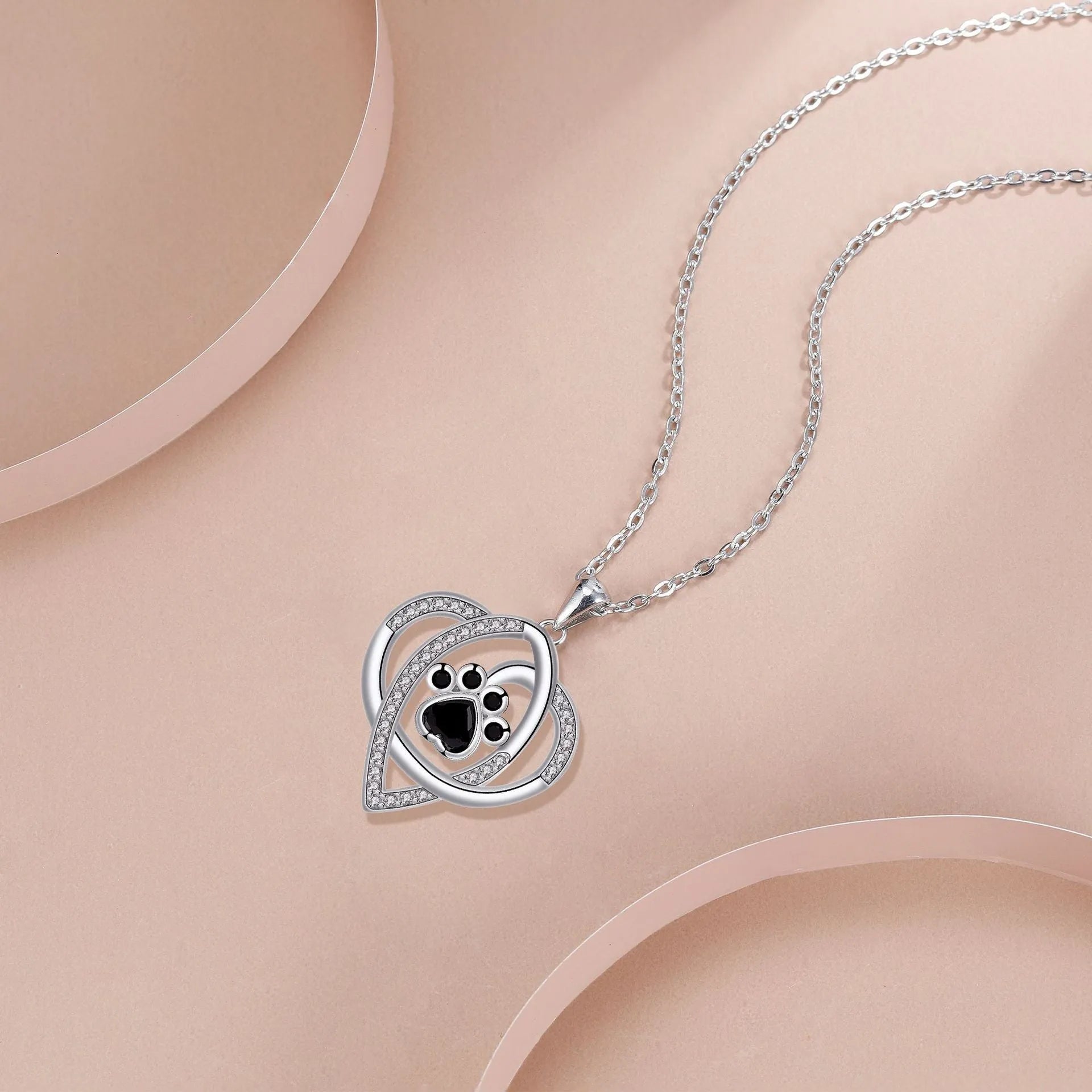 Close-up of electroplated copper paw print necklace pendant on adjustable cross chain
