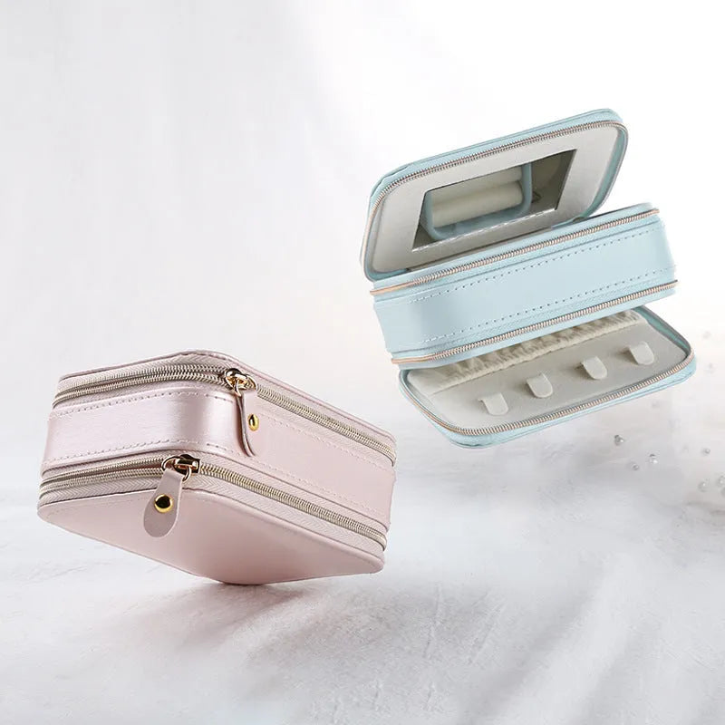 Small PU zipper jewellery box in light blue with fabric lining, 11.5x8.5x5cm, open to show rings and earrings