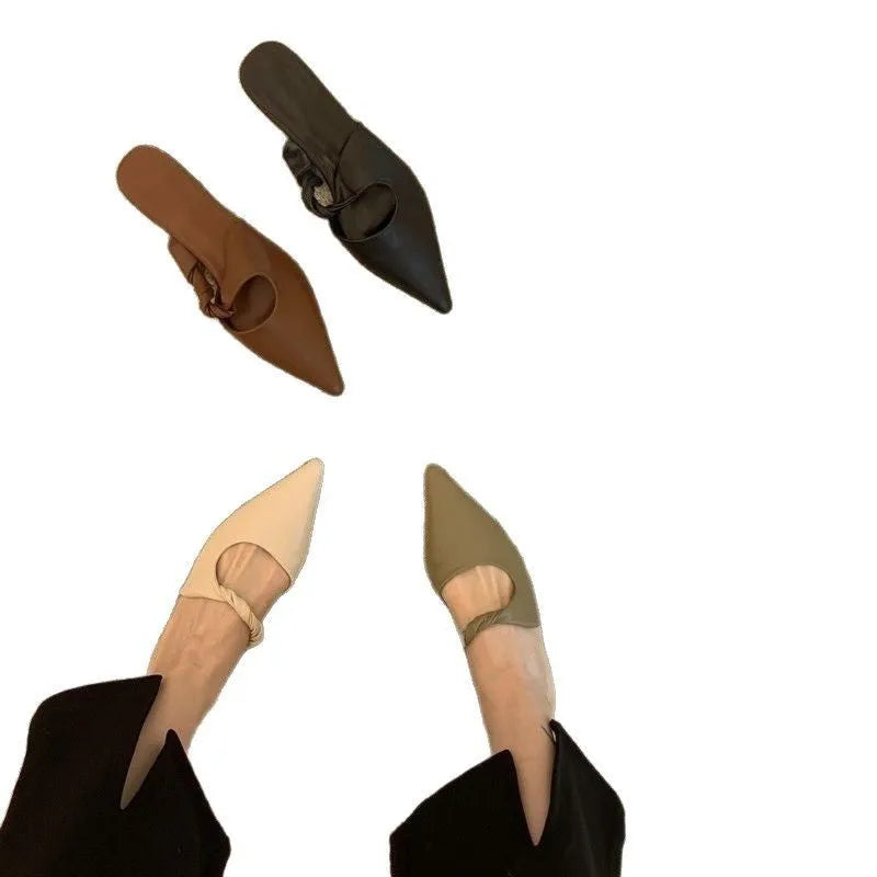 Women's soft leather semi-toe box slippers in black with rubber sole, side view.