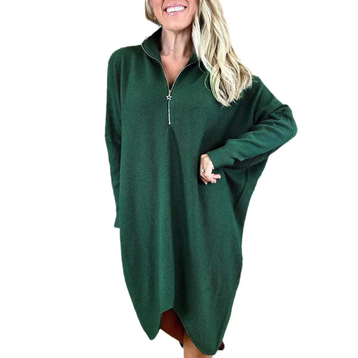 A woman modelling a loose-fitting dark green knitted dress with a front zipper detail and raglan sleeves.