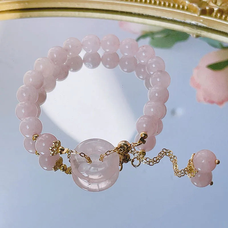 Crystal safety buckle bracelet for women in pink with peace buckle design on white background